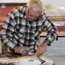 Fred Schaaf viser hvordan man sløyer fisk. Foto: Lise Åserud / NTB scanpix